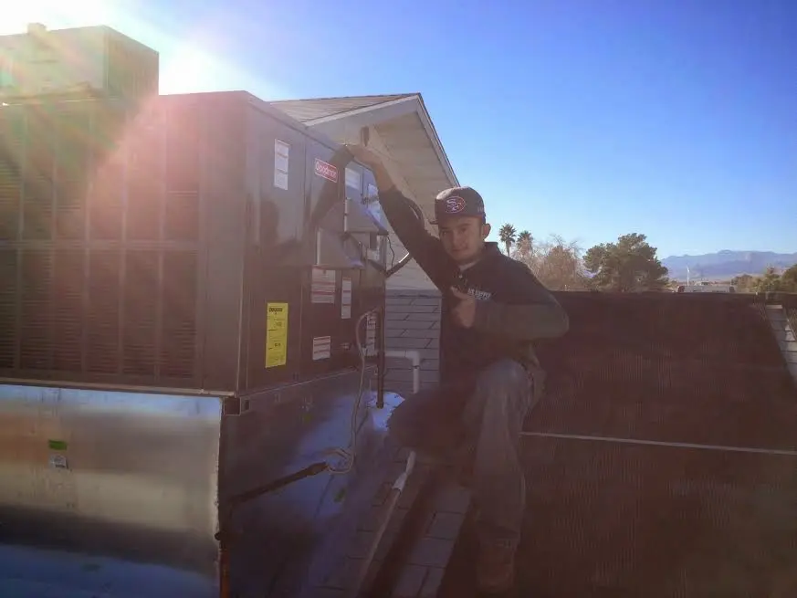 HVAC technician performing AC Tune-Up on a rooftop unit in Brentwood